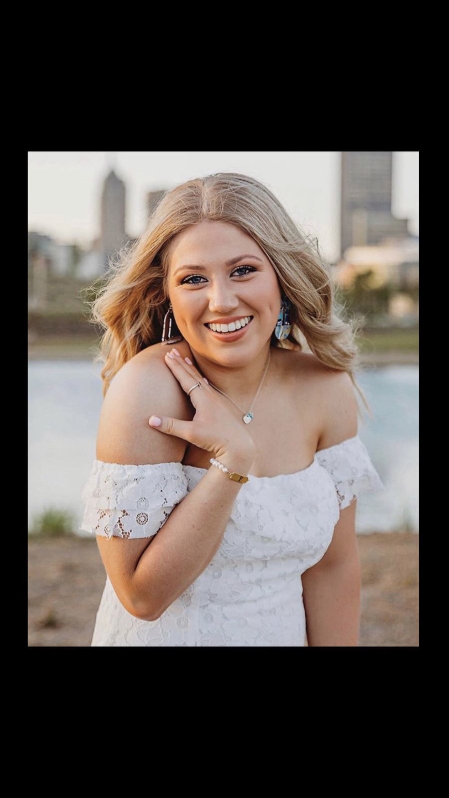 Client glowing with a custom-blended Soleil airbrush tan by the Oklahoma City skyline